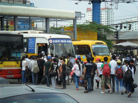 Nhờ sự hướng dẫn của tình nguyện viên, sĩ tử xếp hàng dài đi lên xe bus về điểm thi ở Hưng Yên.